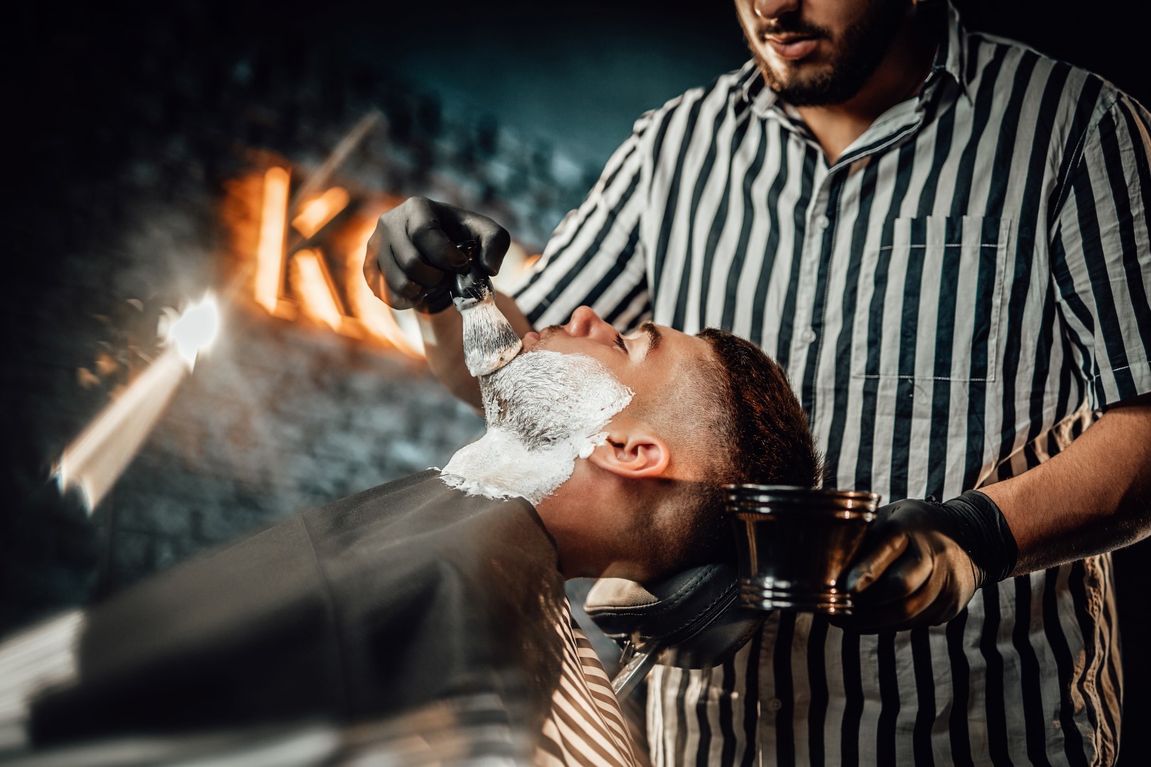 male receiving a hot shave at barbershop