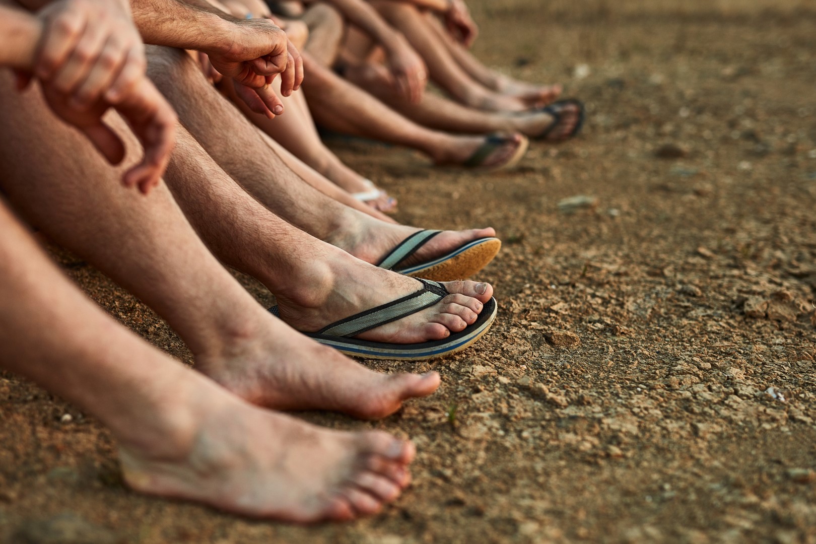 Men sitting on beach showing their feet after a Men's pedicure